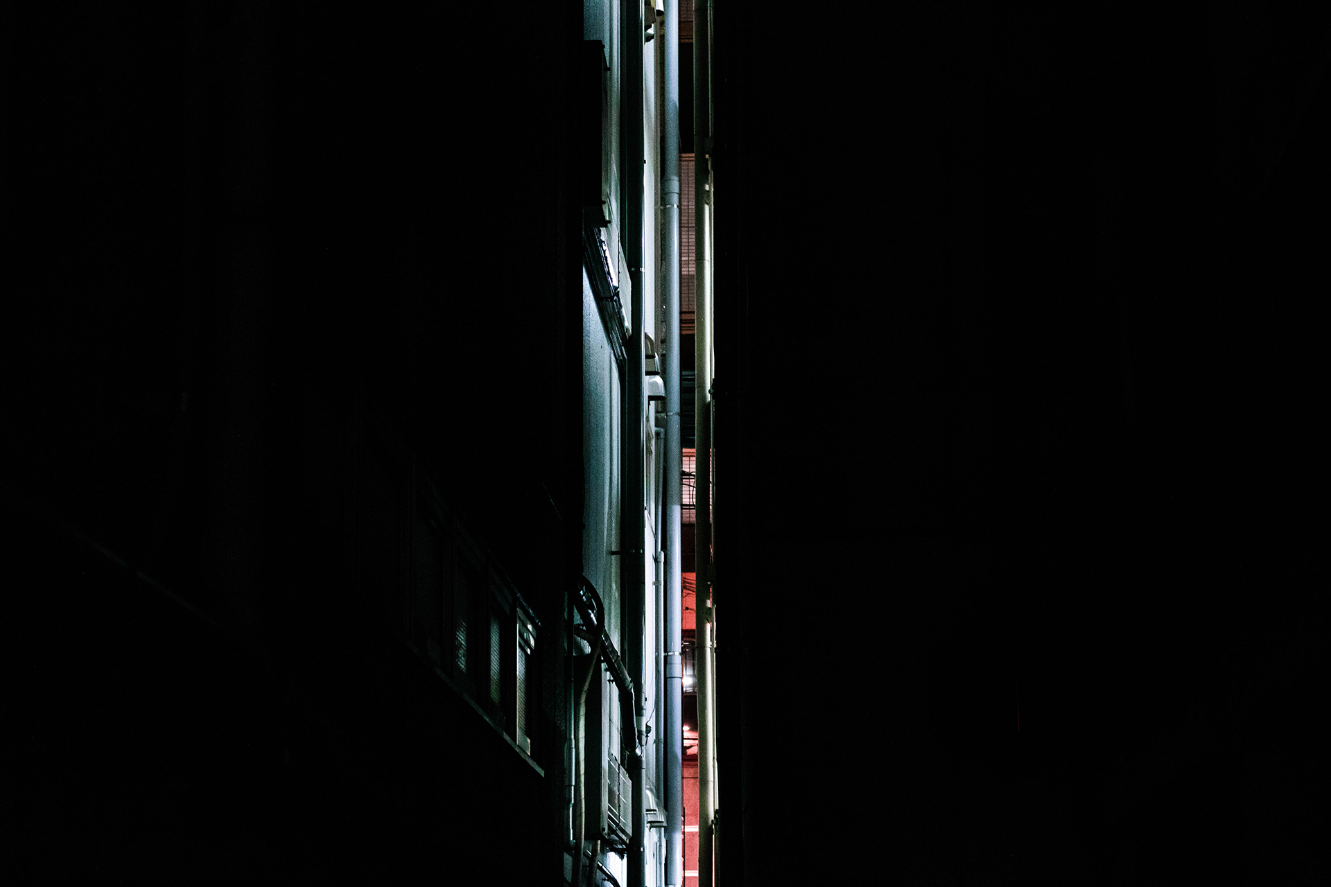 Single slit of light between two modern buildings.